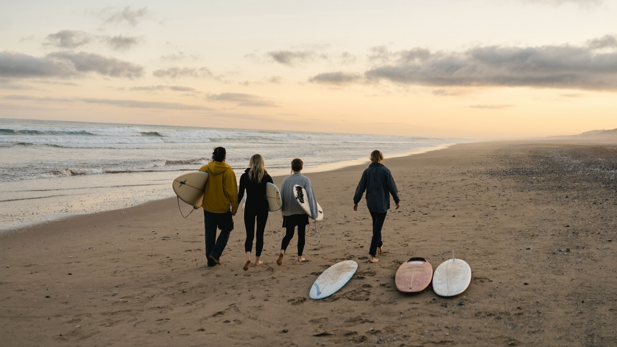 Saltfold About Us — family group walking back from a surf session at dusk